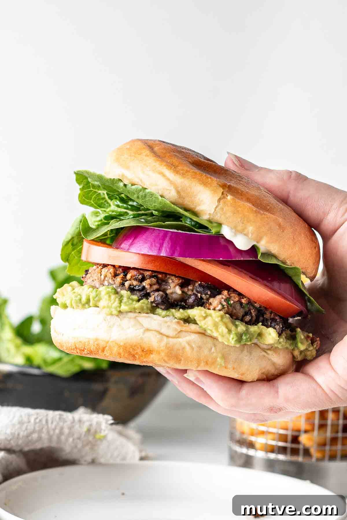 Hand holding a black bean burger. 