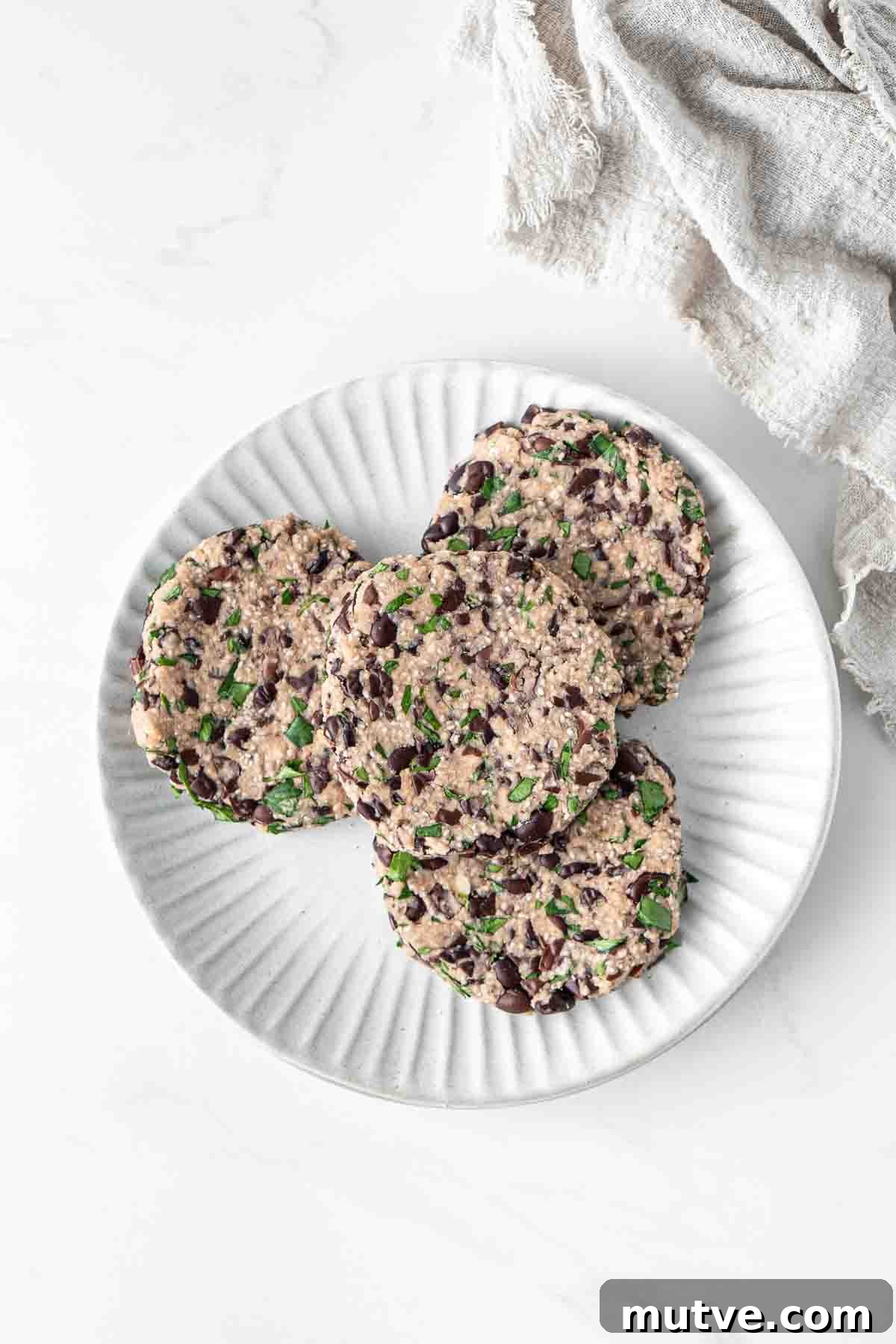 Uncooked black bean burger patties shaped into disks on a plate.