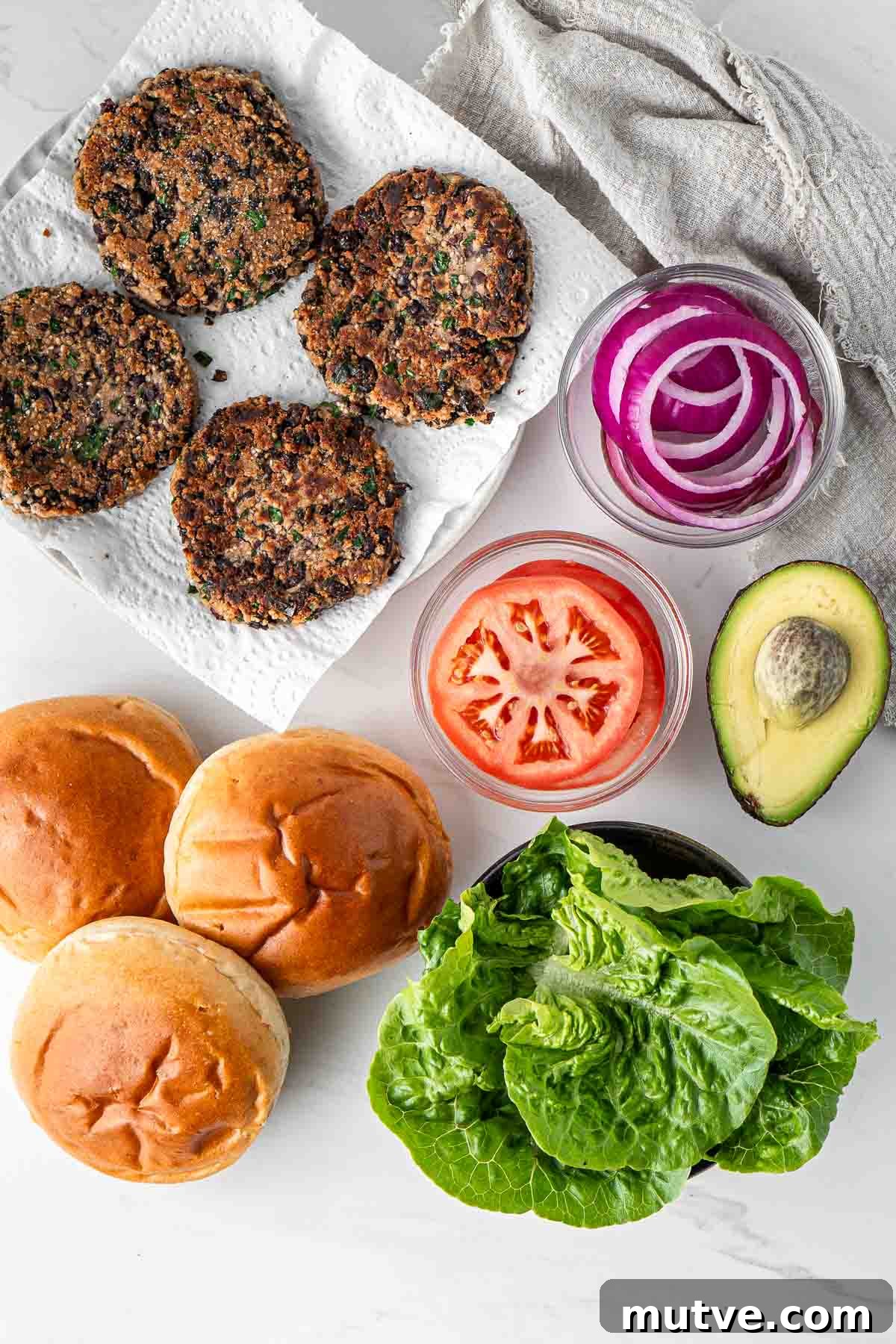 Cooked black bean burgers with all ingredients to assemble.