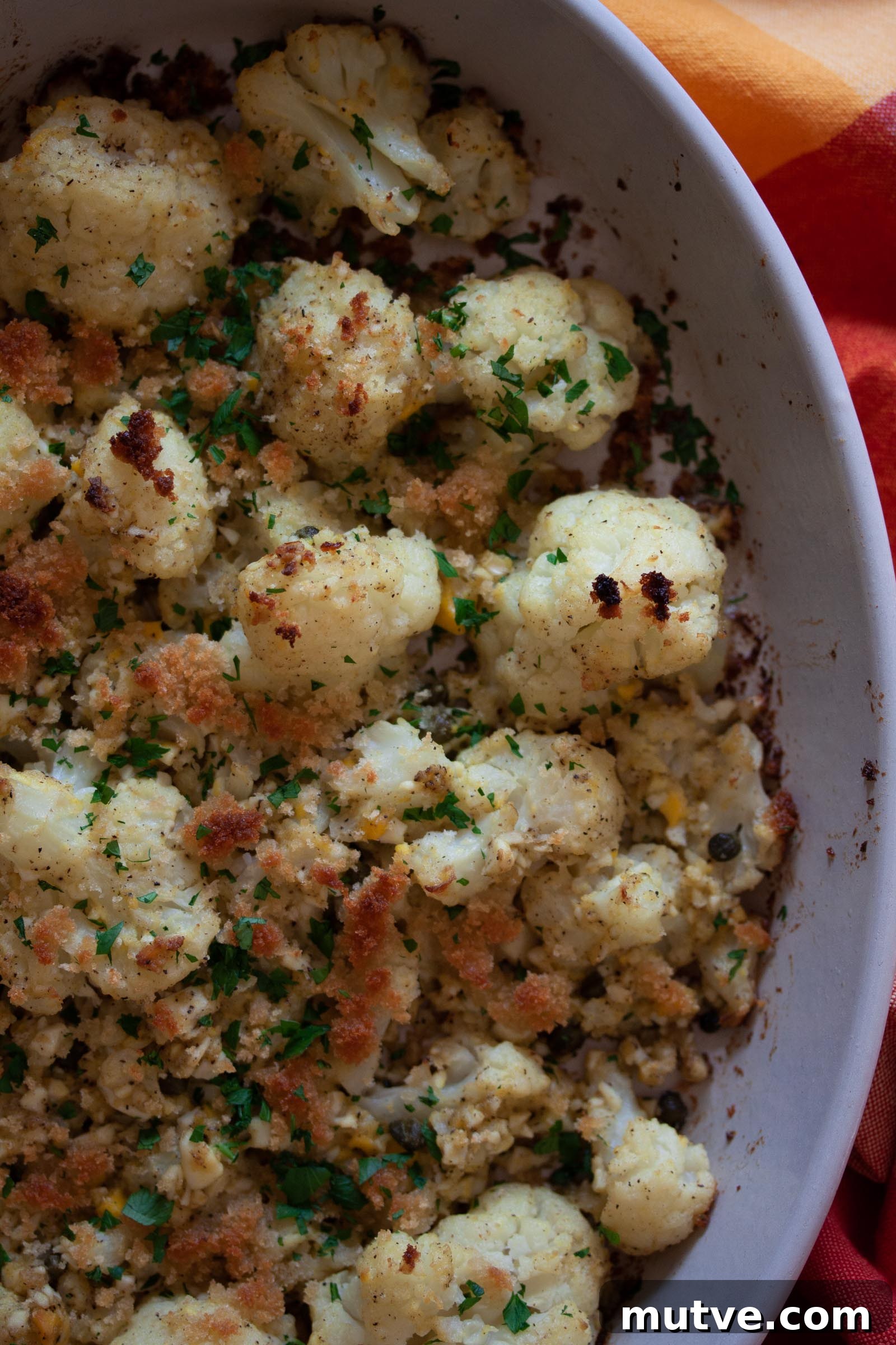 A close up of the finished cauliflower polonaise recipe in a baking dish.
