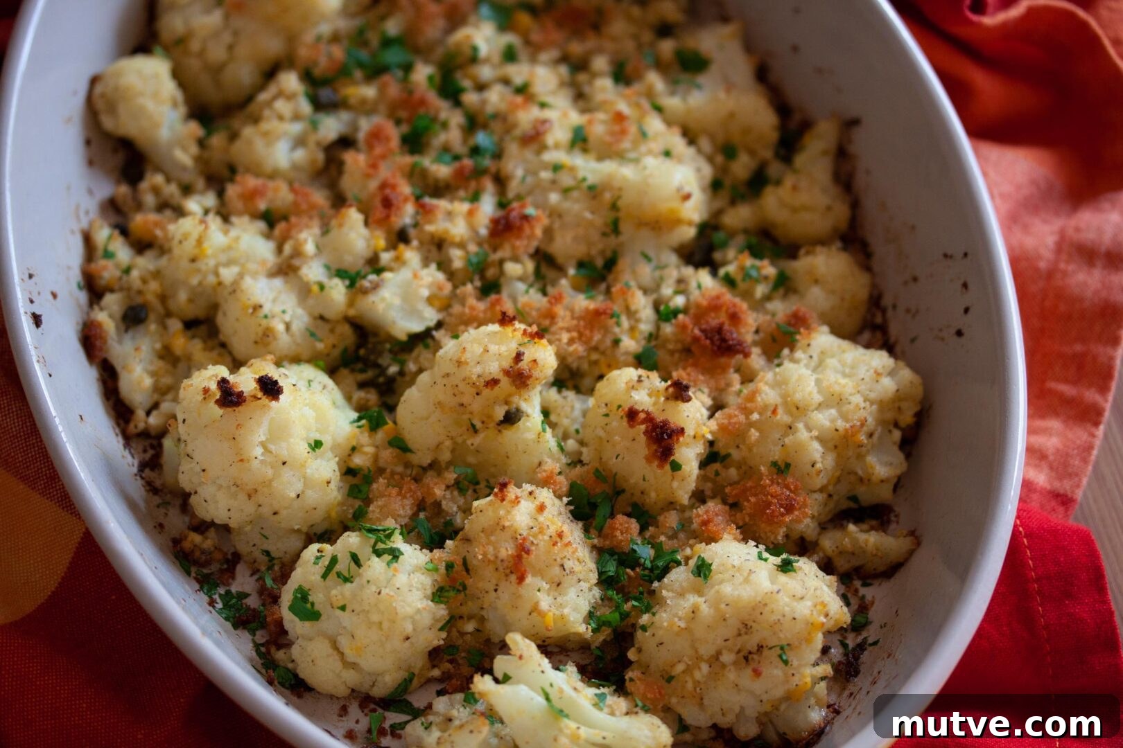 A baking dish full of the recipe served on a red towel. 
