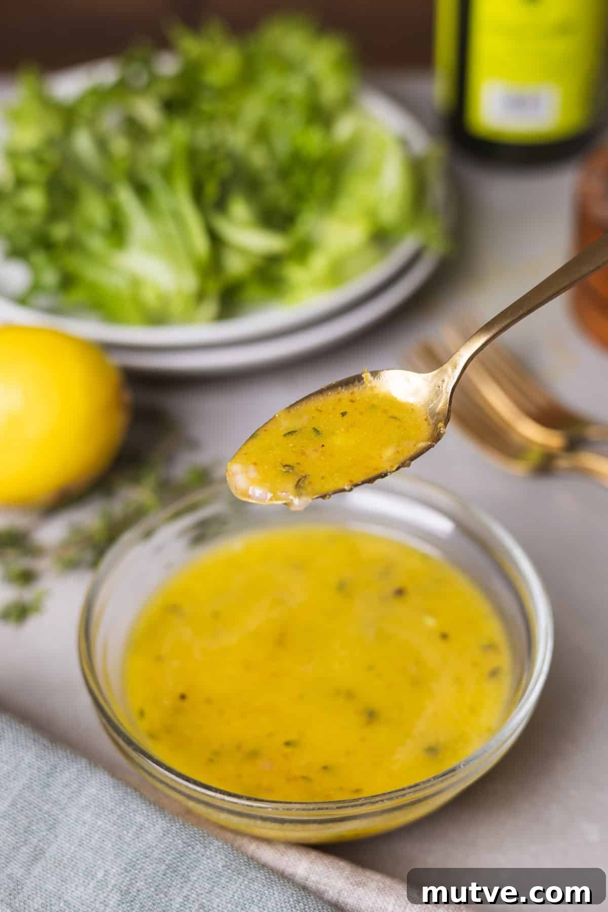 A close up of a spoonful of lemon thyme vinaigrette.