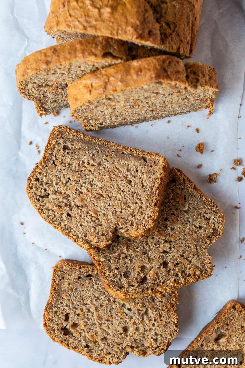 sliced loaf of cake on a sheet of white baking parchment.