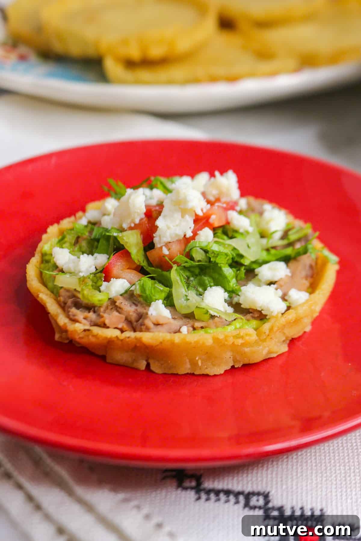 Traditional Mexican Refried Bean Sopes Recipe 2 Sope de frijoles on a red plate
