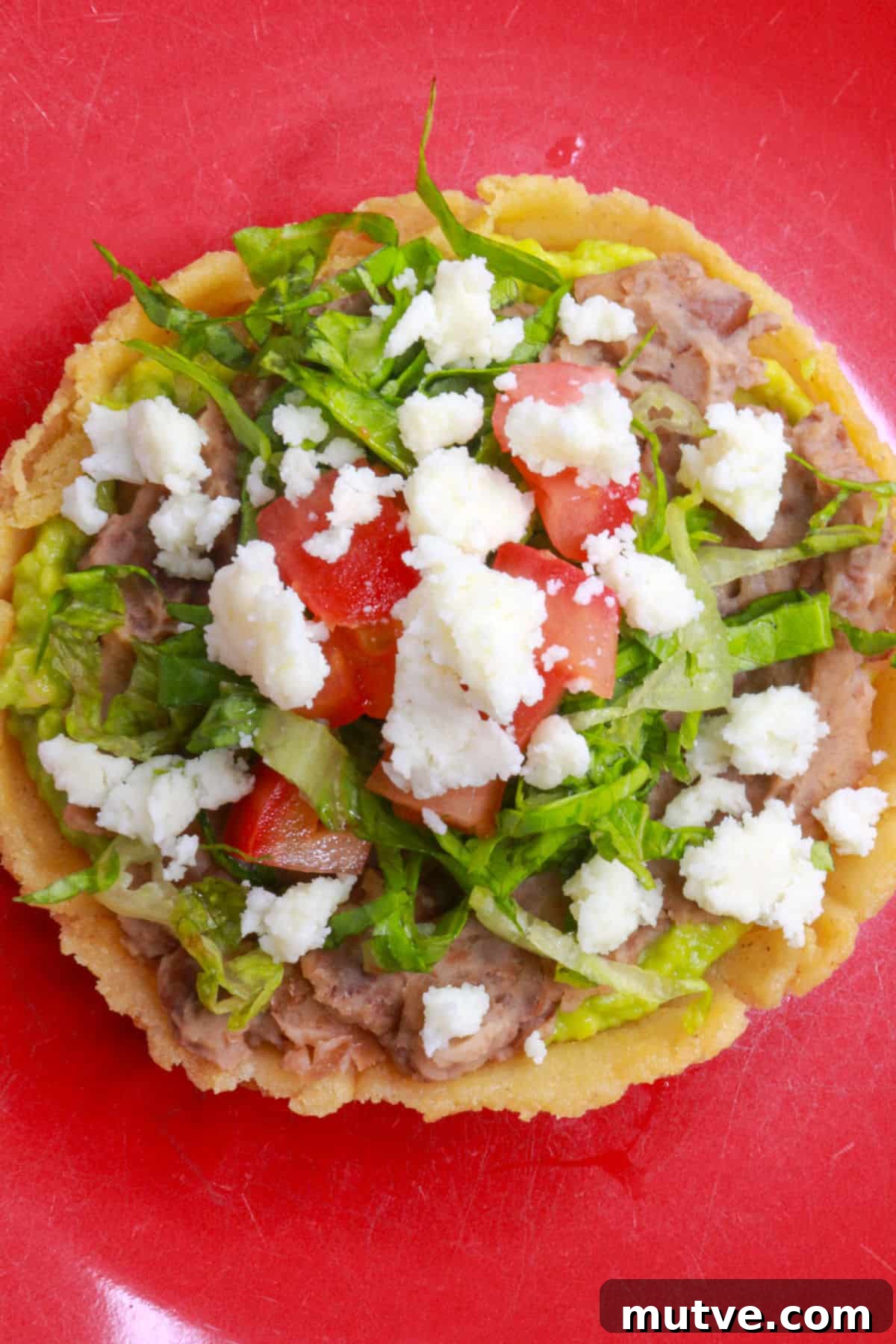 Traditional Mexican Refried Bean Sopes Recipe 11 Sope de frijoles garnished with lettuce, tomato and queso fresco