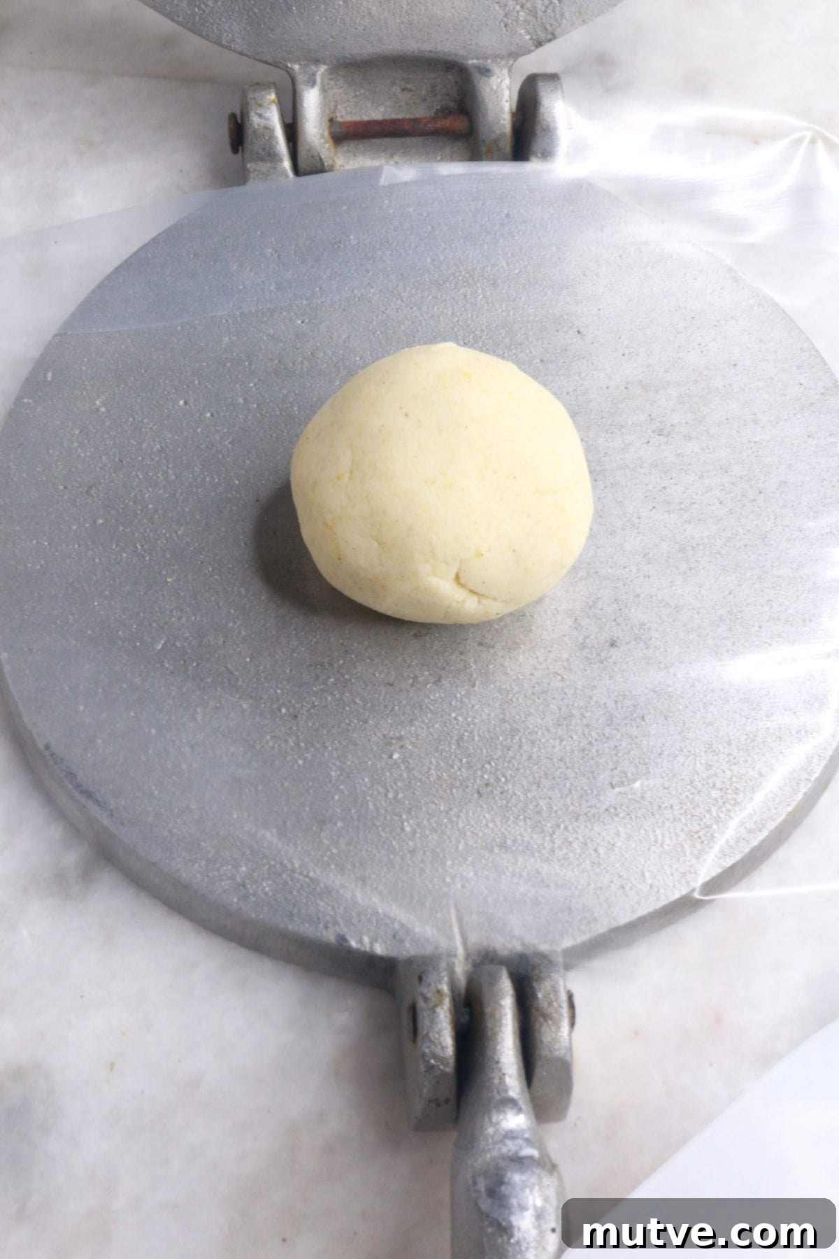 Traditional Mexican Refried Bean Sopes Recipe 6 Ball of masa dough on an open tortilla press
