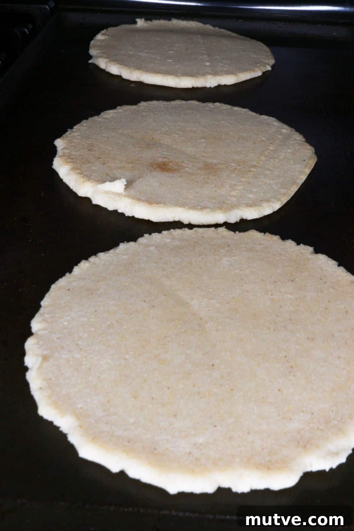 Traditional Mexican Refried Bean Sopes Recipe 7 Three thick corn tortillas on a comal