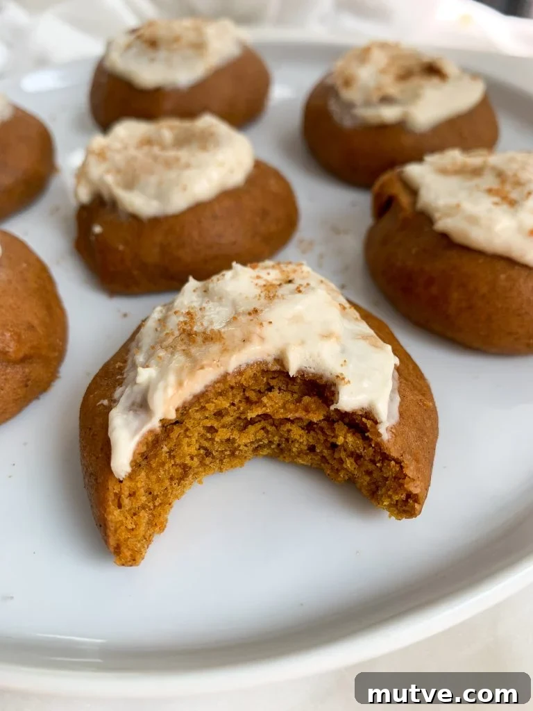 whole wheat pumpkin cookies with a maple cream cheese frosting on a white plate