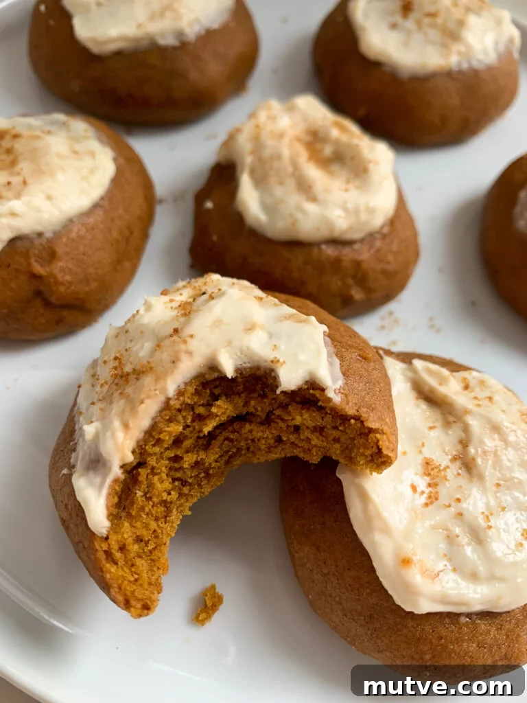 whole wheat pumpkin cookies with a maple cream cheese frosting on a white plate