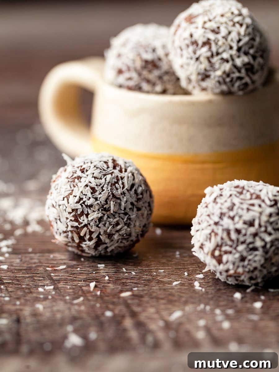 gluten free rum balls coated in coconut on a brown woodface