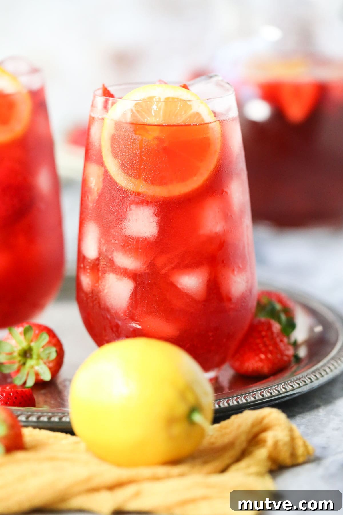 Strawberry sweet iced tea in tall glasses on a metal serving tray.