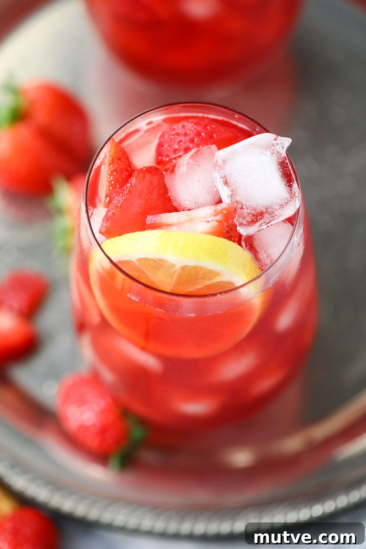 Strawberry sweet iced tea in tall glasses on a metal serving tray.