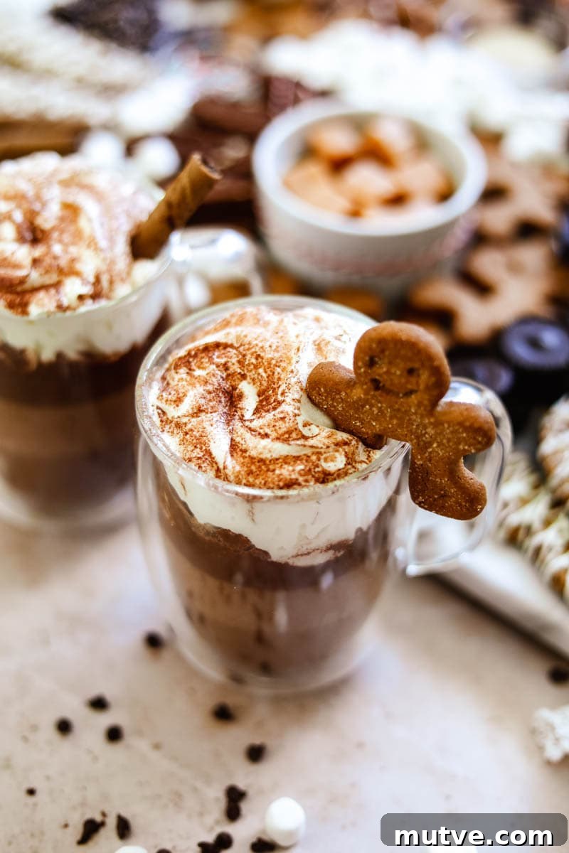 Hot Chocolate Bar Recipes and Ideas for Parties 5 How to make a hot cocoa charcuterie board with a double-wall glass mug with hot chocolate, gingerbread man, and whipped cream.