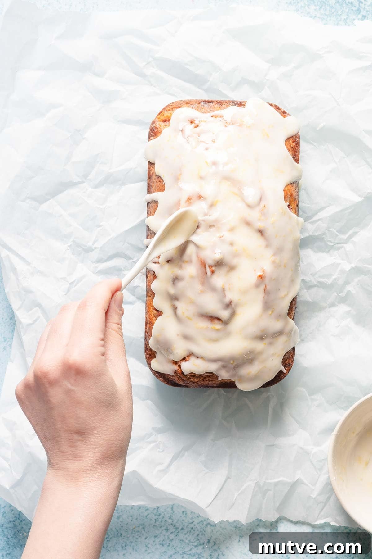 lemon glaze being spread over loaf cake.