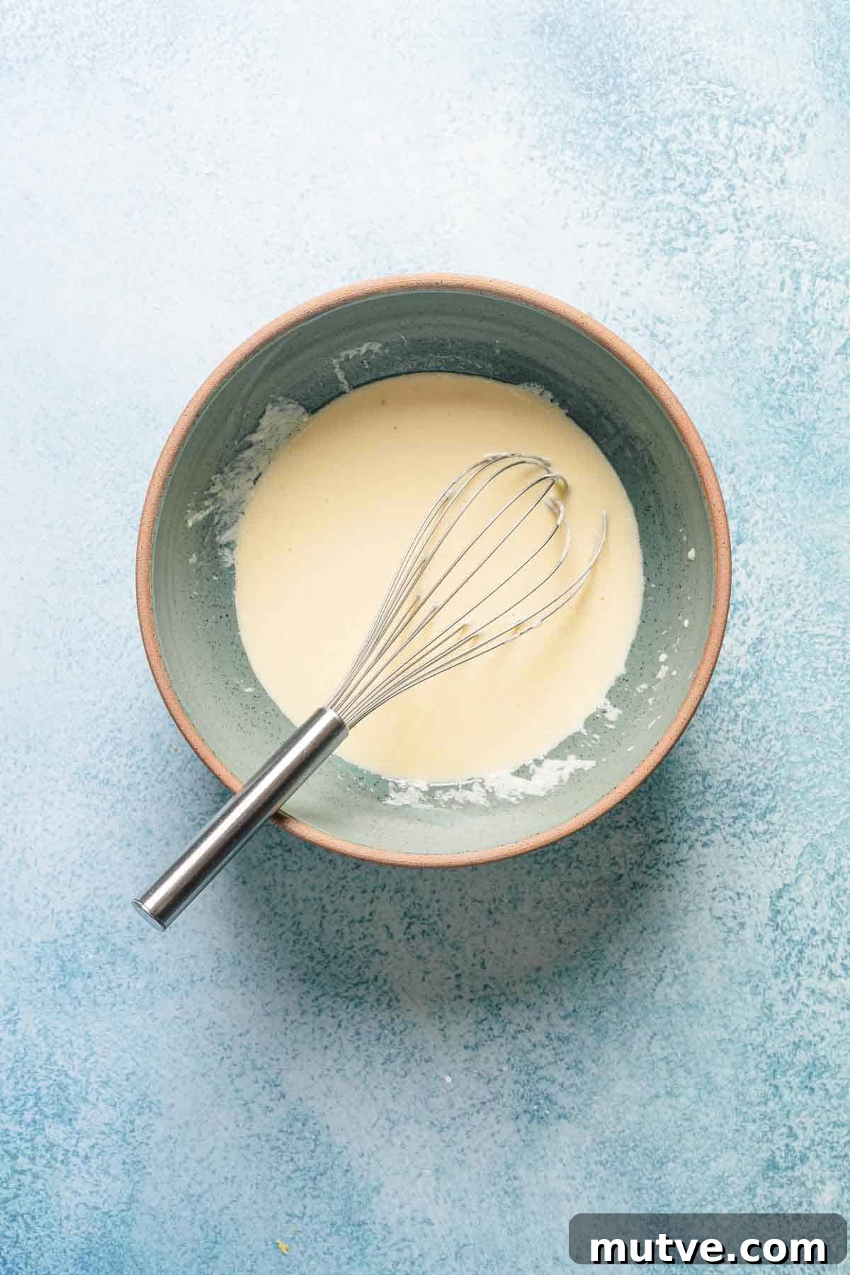 wet ingredients for raspberry loaf cake in bowl with whisk.