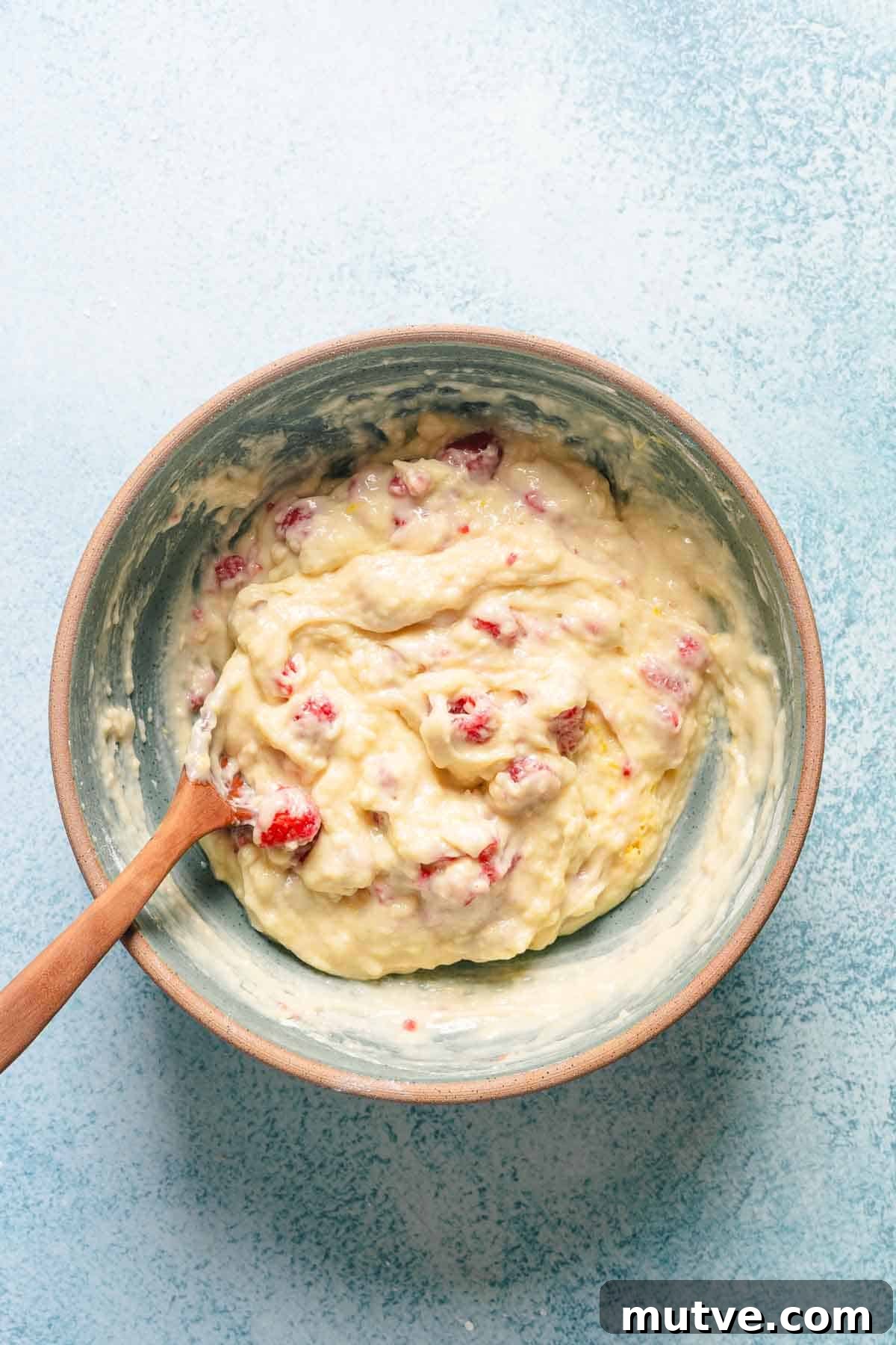 cake batter with raspberries mixed in in bowl.