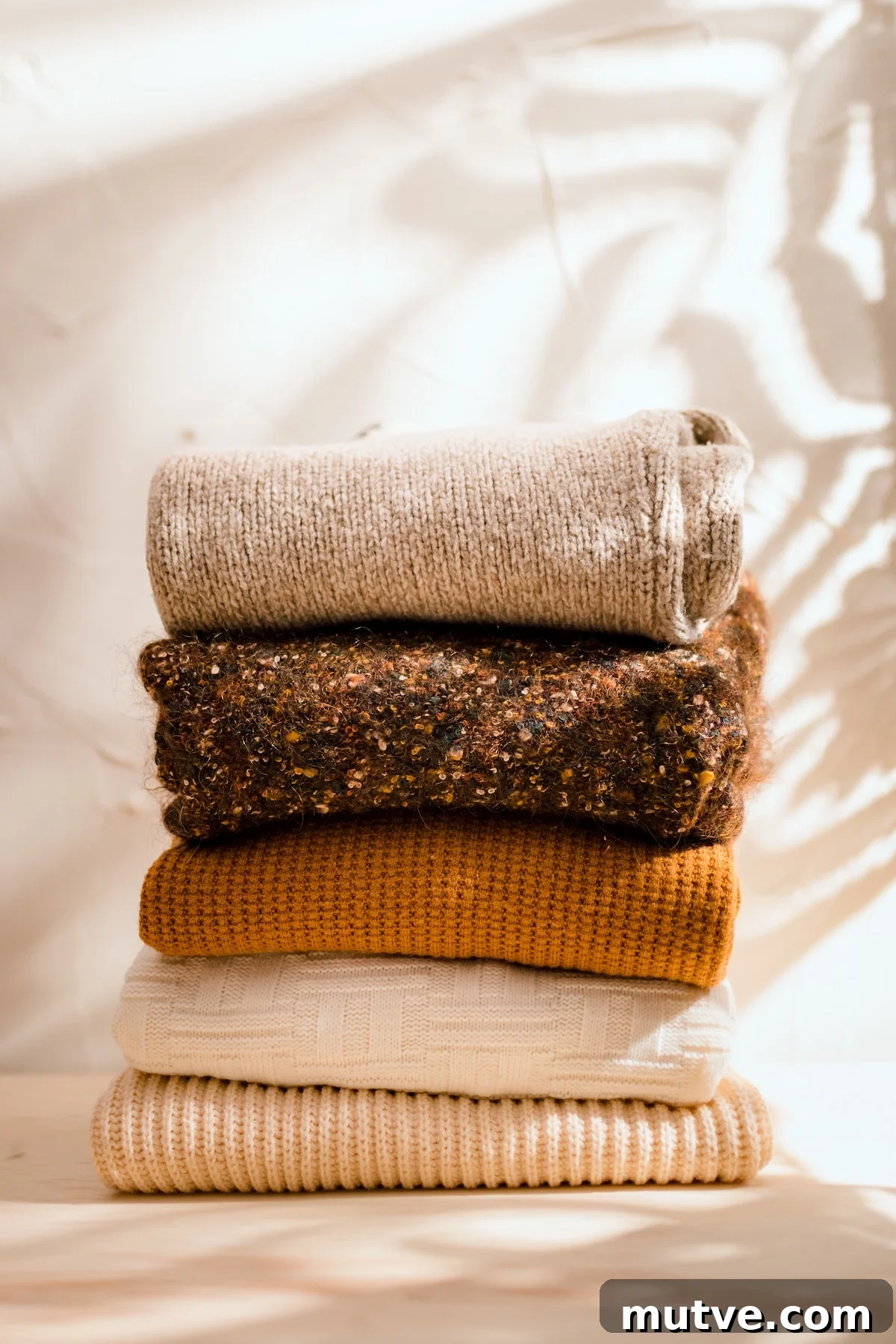 Fall Capsule Wardrobe: Build a Versatile Seasonal Closet 2 Fall sweaters stacked on a textured background