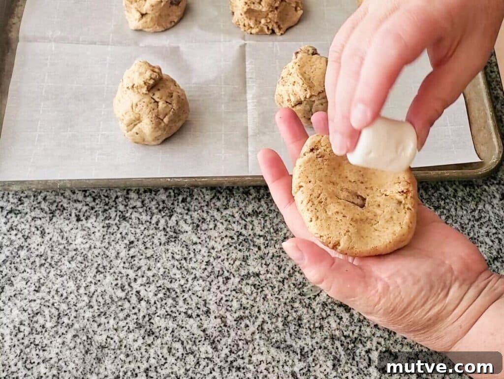 Gluten-Free Smores Cookies with Gooey Marshmallow and Chocolate 9 adding large marshmallow to flattened ball of dough.