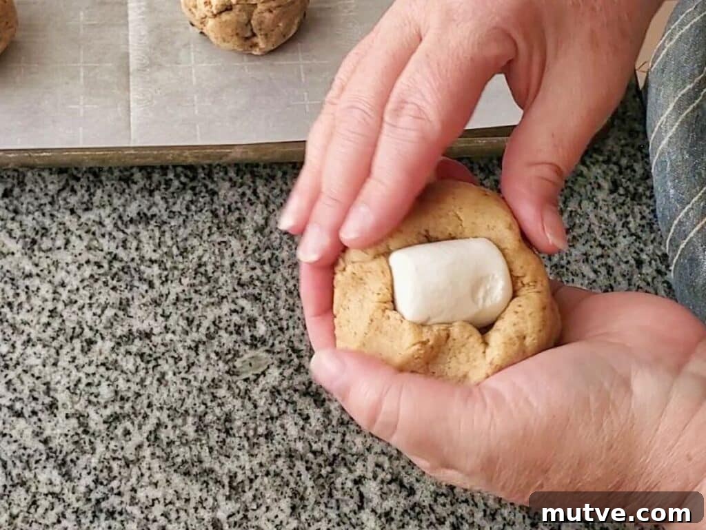 Gluten-Free Smores Cookies with Gooey Marshmallow and Chocolate 10 wrapping cookie dough around marshmallow.