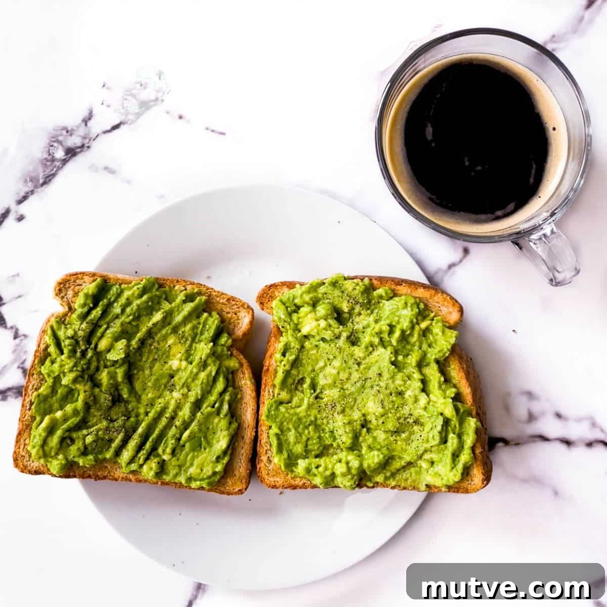Air fryer toast topped with mashed avocado and a cup of coffee.