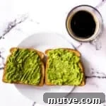 Air fryer toast topped with mashed avocado and a cup of coffee.