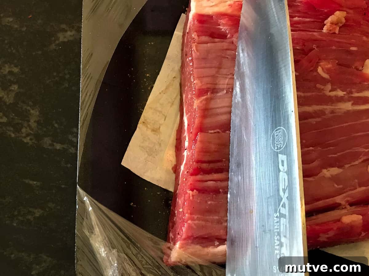 Sizzling Tex-Mex Fajitas Recipe with Peppers and Onions 7 Knife positioned against the grain of flank steak.