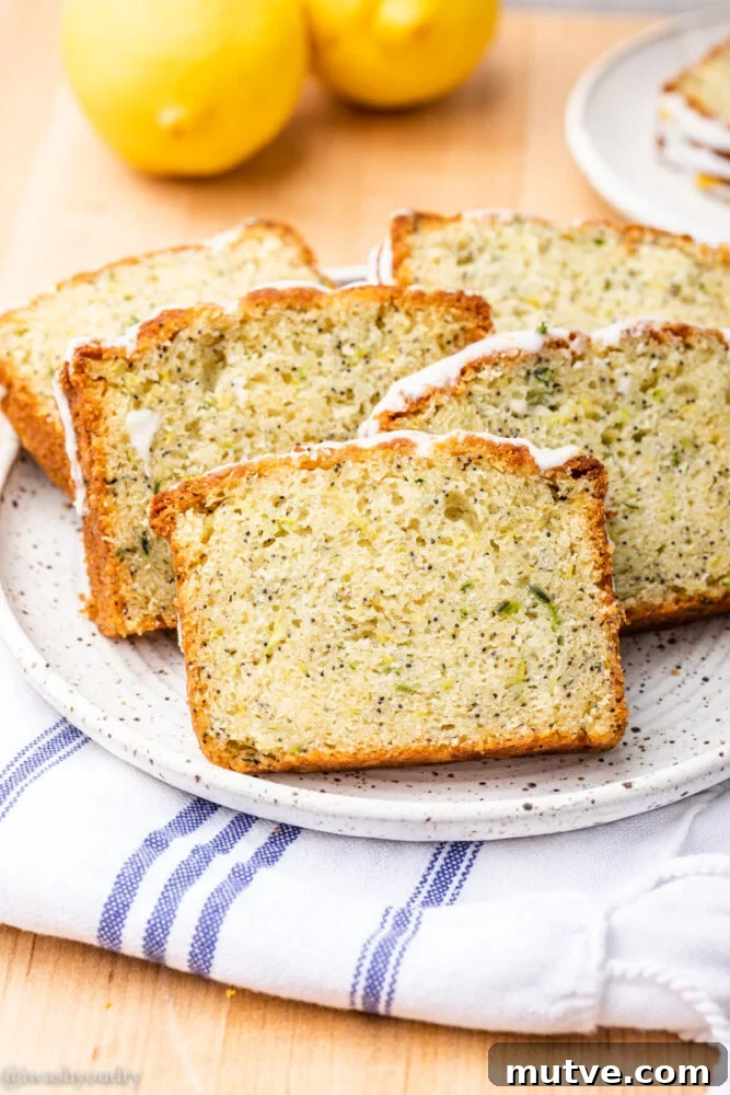 slices of zucchini bread on white plate with lemons.