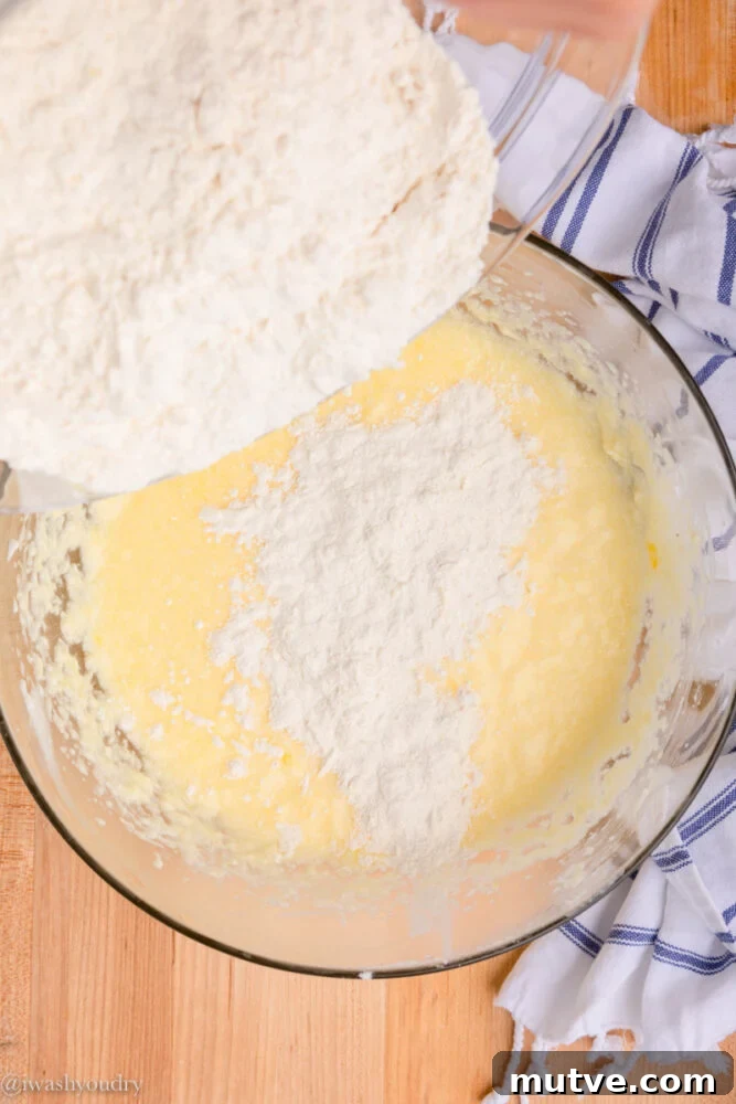 pouring dry flour ingredients into bowl with batter.