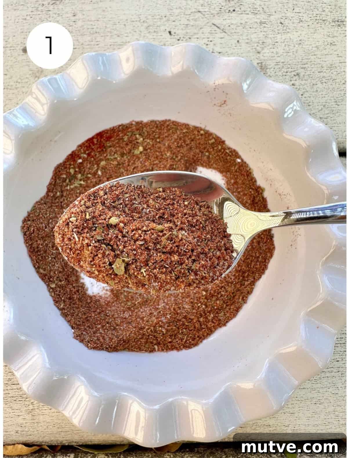 Blended seasoning in a small bowl with a spoon.