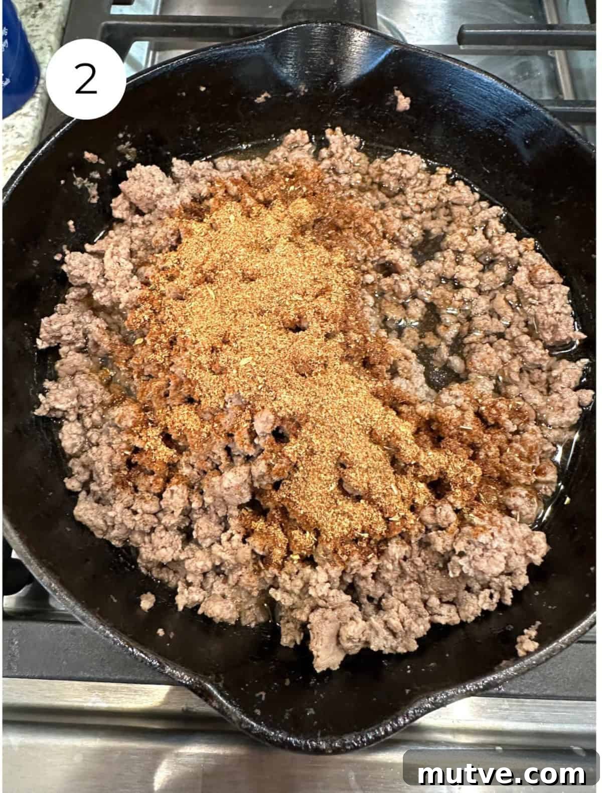 Cooked beef with taco seasoning spice in a skillet.