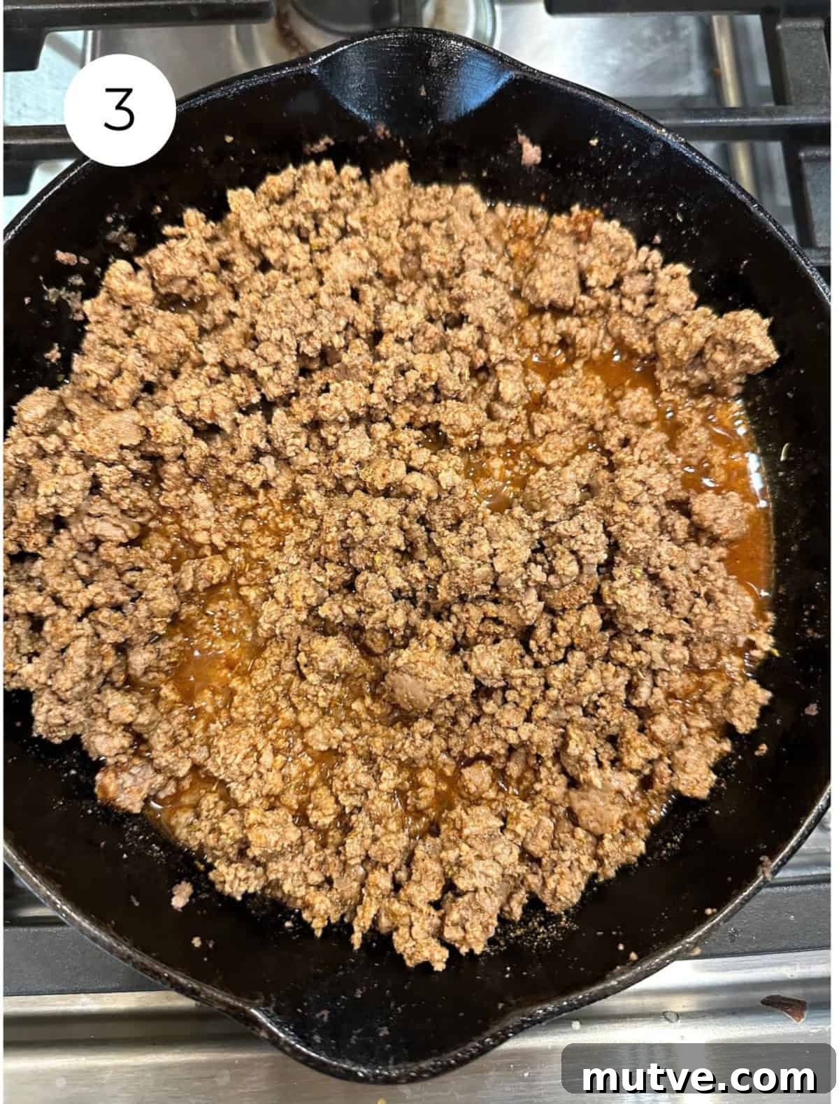 Cooked beef with taco seasoning in a skillet on the stove.
