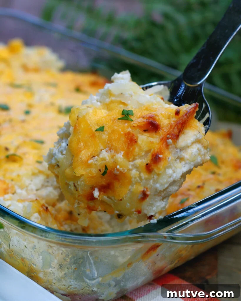 A serving of Cheesy Hashbrown Casserole in a spoon
