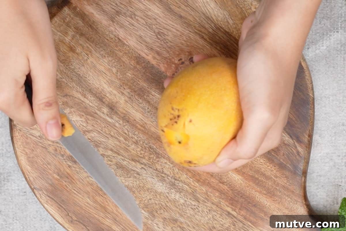 Black tip of the mango removed using a knife.