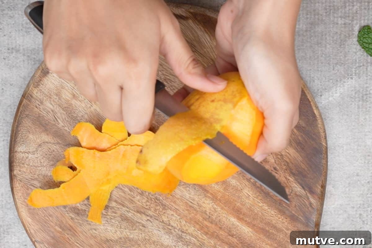 Peeling the mango using a knife.