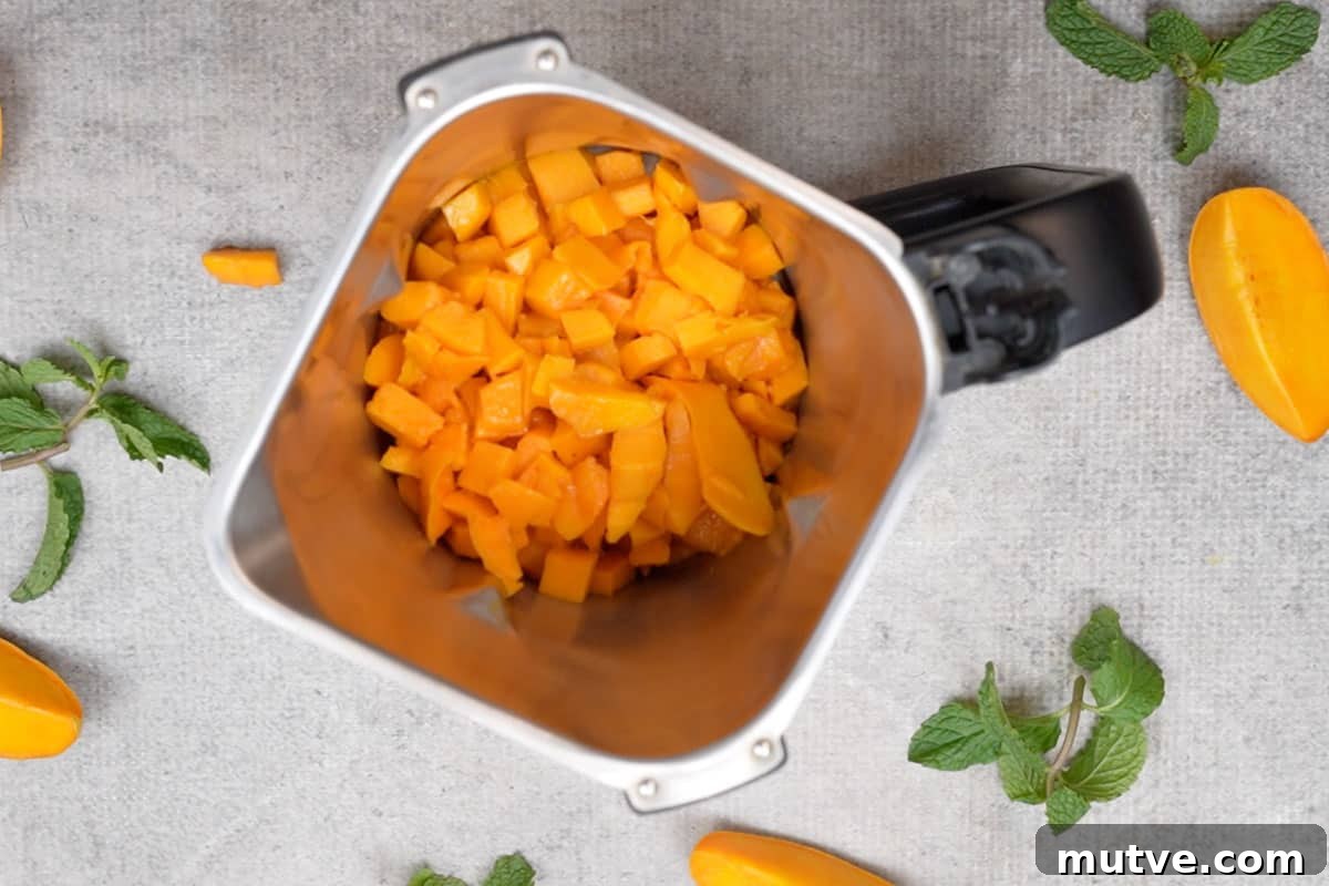 Mango pieces transferred to a blender.