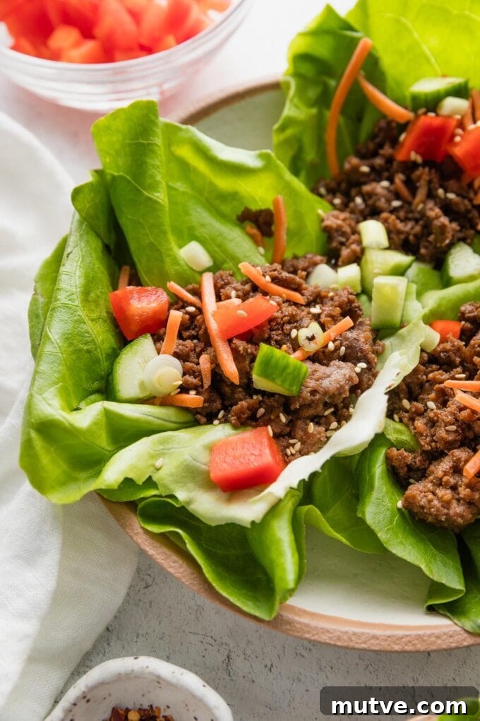 Korean Beef Lettuce Wraps Recipe with Gochujang Glaze 5 Angled view of Korean beef lettuce wraps arranged on a plate.