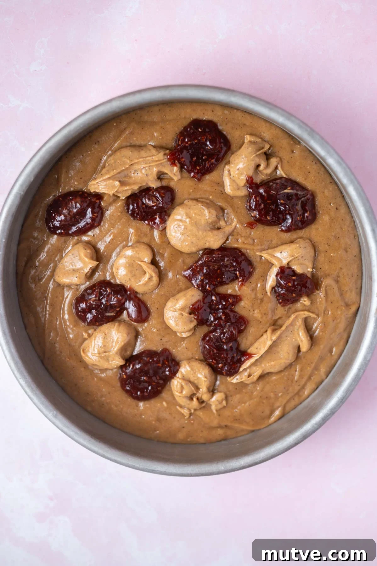 dollops of jam and peanut butter over cake batter