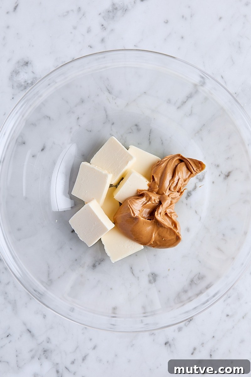 Sliced unsalted butter and creamy peanut butter in glass bowl