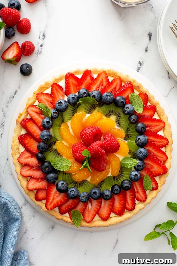 How to Make a Fresh Fruit Tart with Vanilla Custard 2 A French Fresh Fruit Tart with strawberries, kiwi, mandarin oranges, raspberries and blueberries on a white platter.