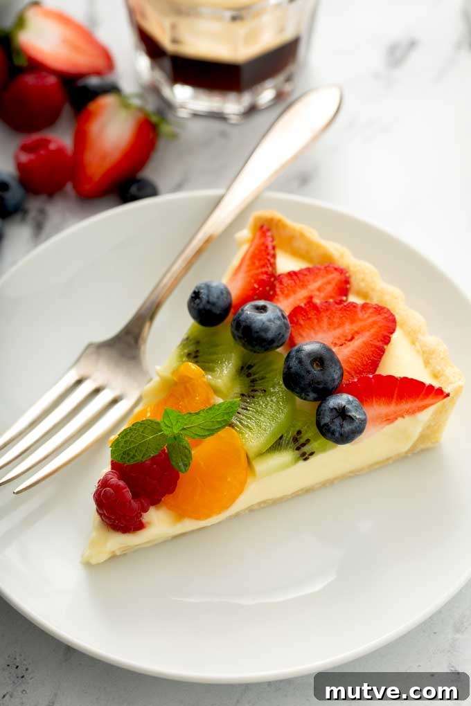 How to Make a Fresh Fruit Tart with Vanilla Custard 3 A slice of the best fruit tart on a white plate.