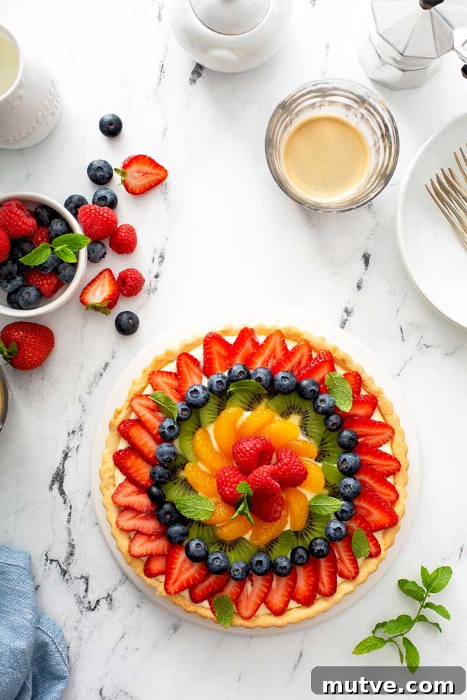 How to Make a Fresh Fruit Tart with Vanilla Custard 7 Top view of fresh fruit tart on a white platter.