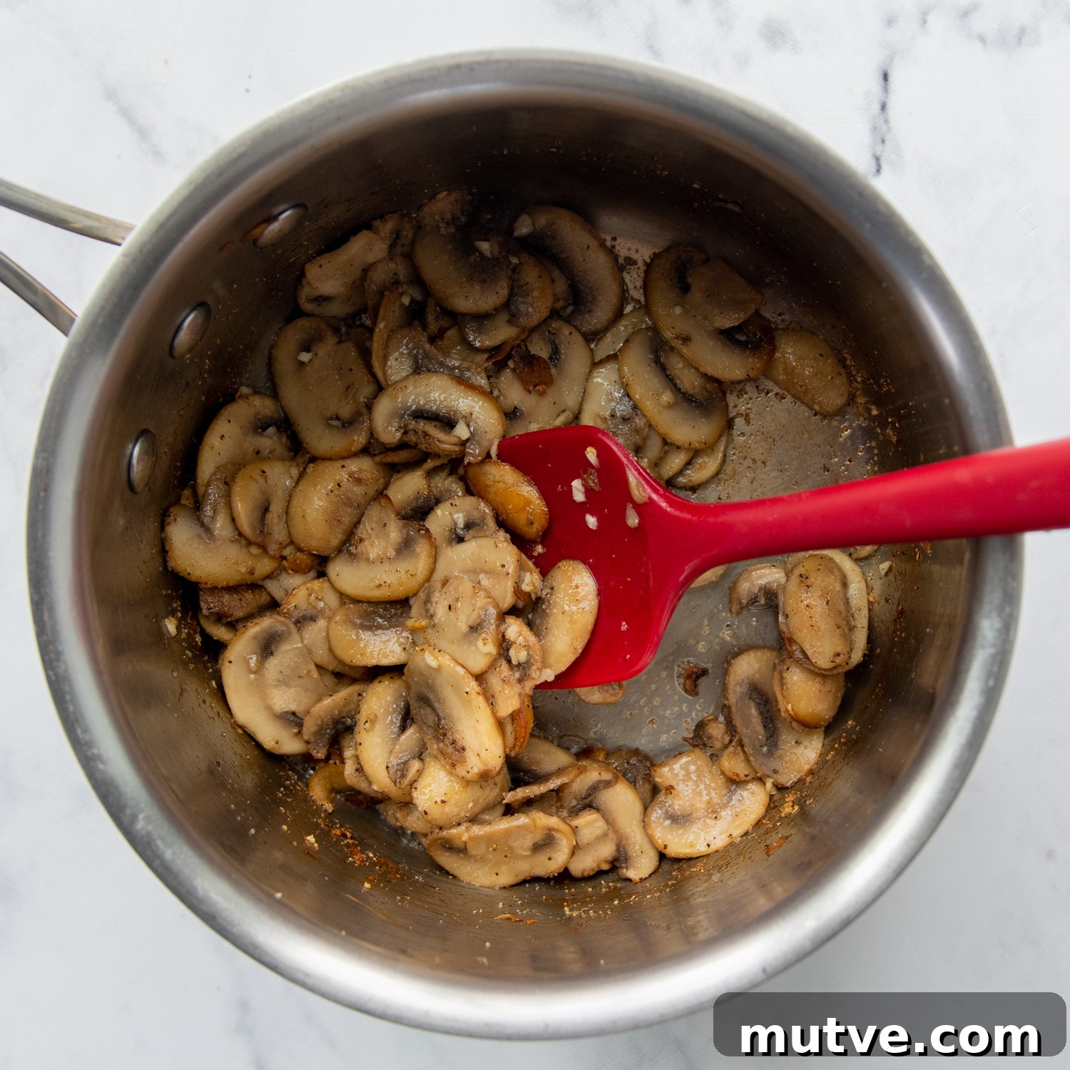Gluten-Free Cream of Mushroom Soup Recipe 3 mushrooms cooking in a small saucepan.