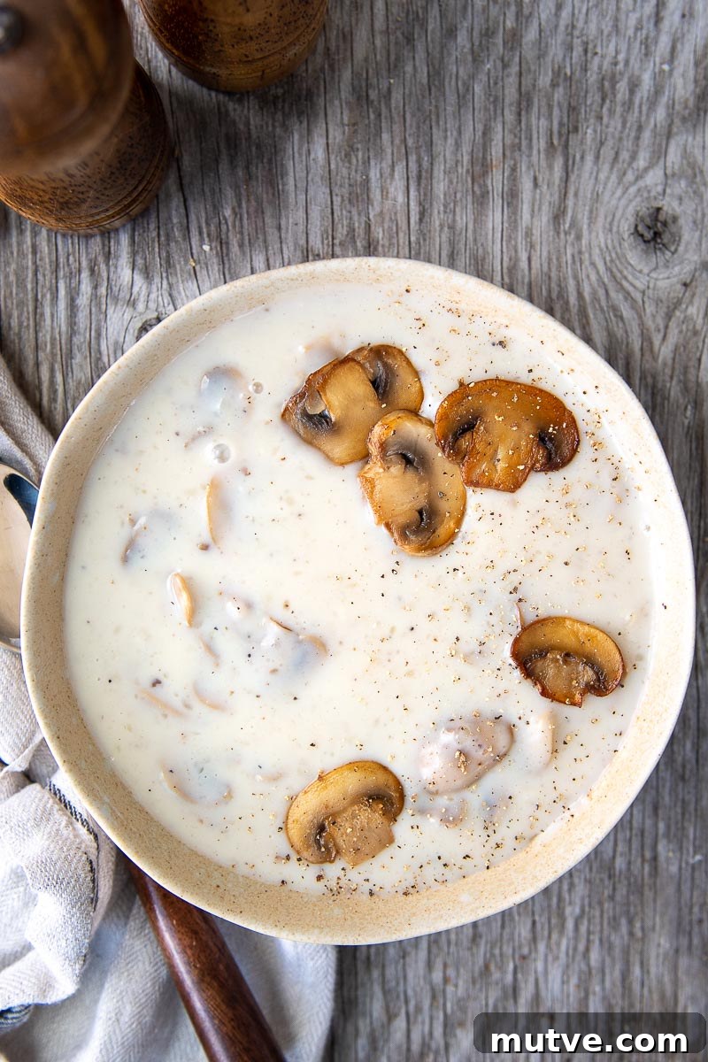 Gluten-Free Cream of Mushroom Soup Recipe 7 overhead shot of mushroom soup in a white bowl sitting on a wood board