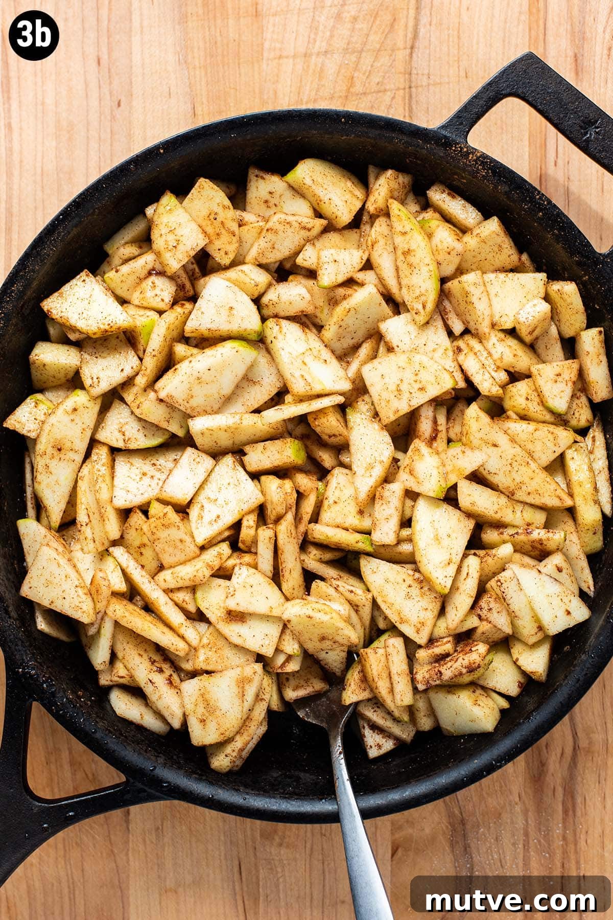 Skillet Apple Crisp Recipe with Cinnamon Oat Topping 6 Sliced raw apples, sugar, and cinnamon in a cast iron skillet.