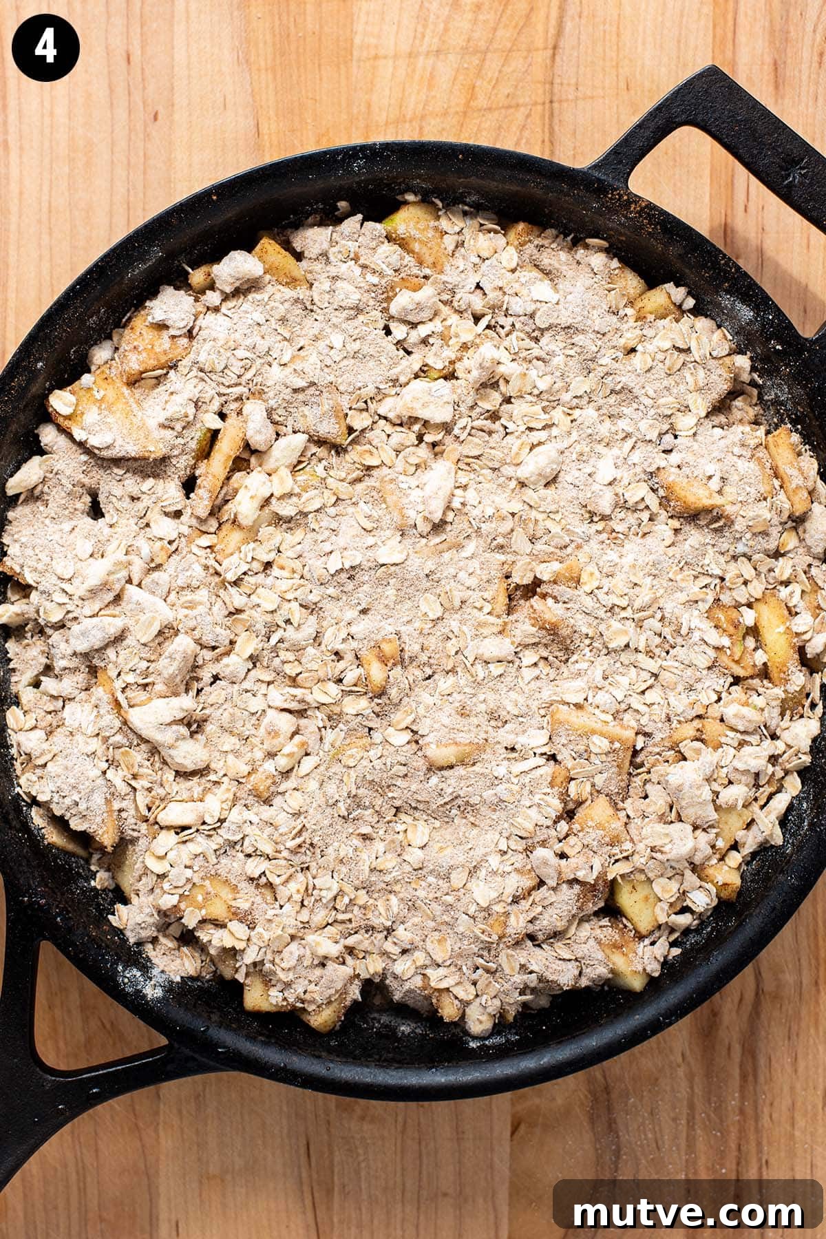Skillet Apple Crisp Recipe with Cinnamon Oat Topping 7 Unbaked apple crisp in a cast iron skillet topped with flour, oats, and brown sugar.