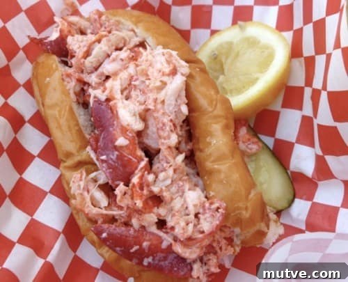 Ordering Lobster Rolls on Weight Watchers at The Lobster Lady 4 Lobster Roll in hot dog bun with lemon wedge from The Maine Lobster Lady food truck.