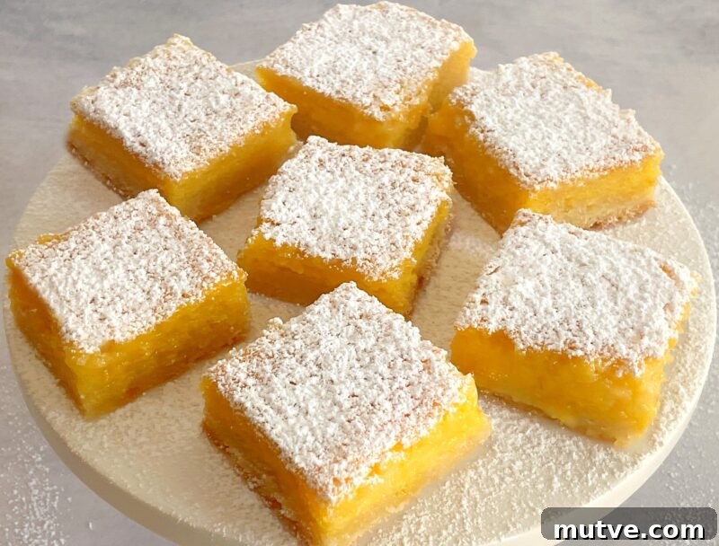 Tangy Passion Fruit Bars Recipe with Shortbread Crust 2 passion fruit bars on a cake plate.