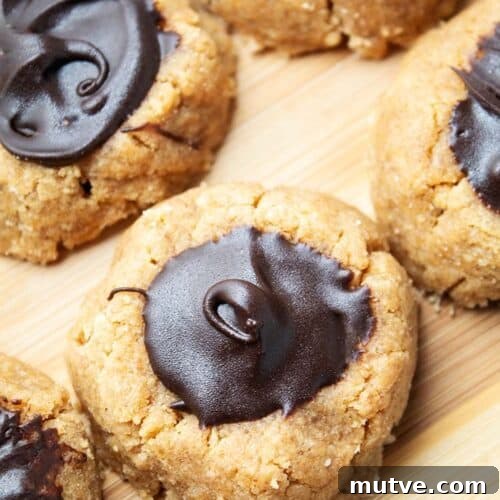 overhead view of keto sugar free peanut butter blossoms lined up together on parchment paper