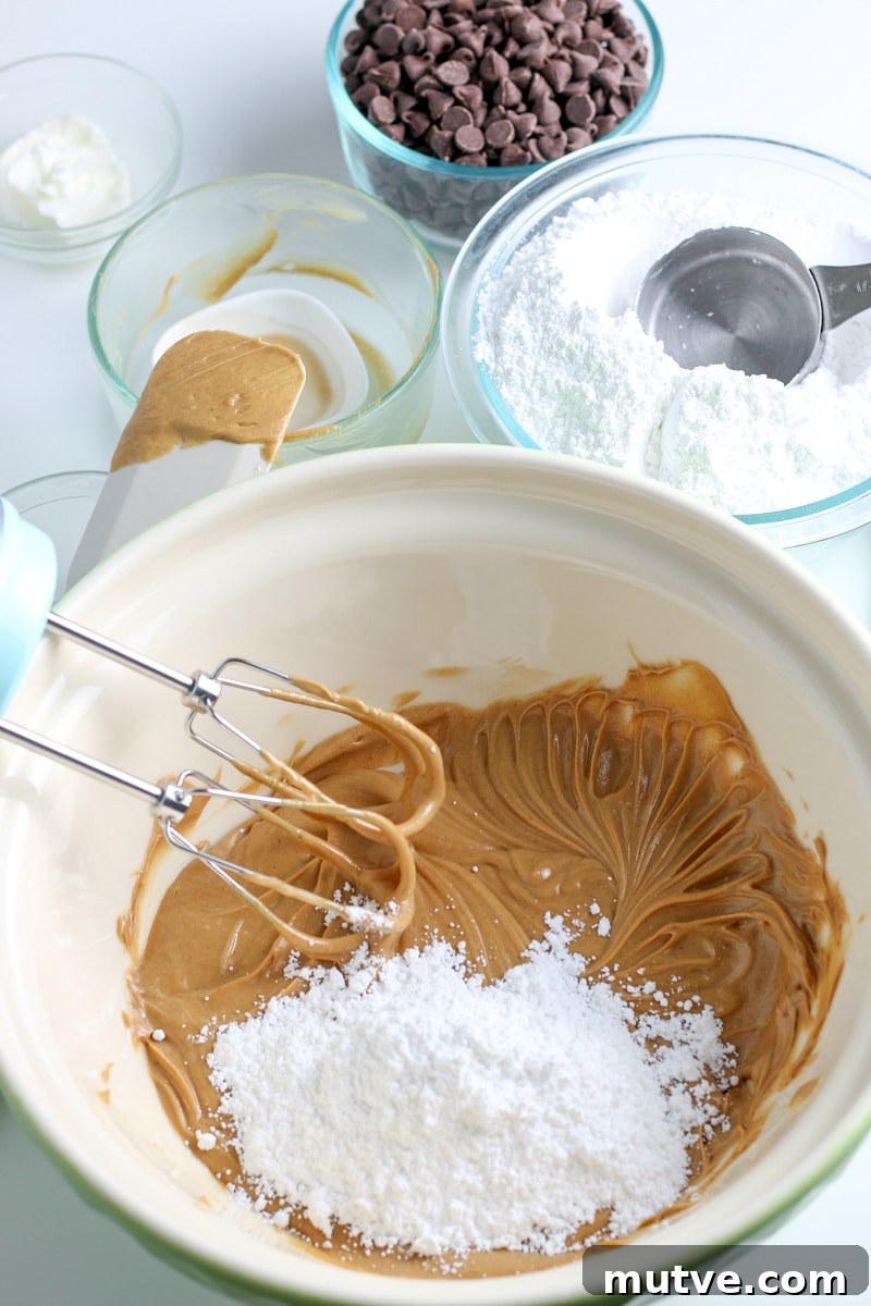 Old Fashioned No Bake Peanut Butter Balls Recipe 5 peanut butter and butter mixture with powdered sugar in a white mixing bowl.
