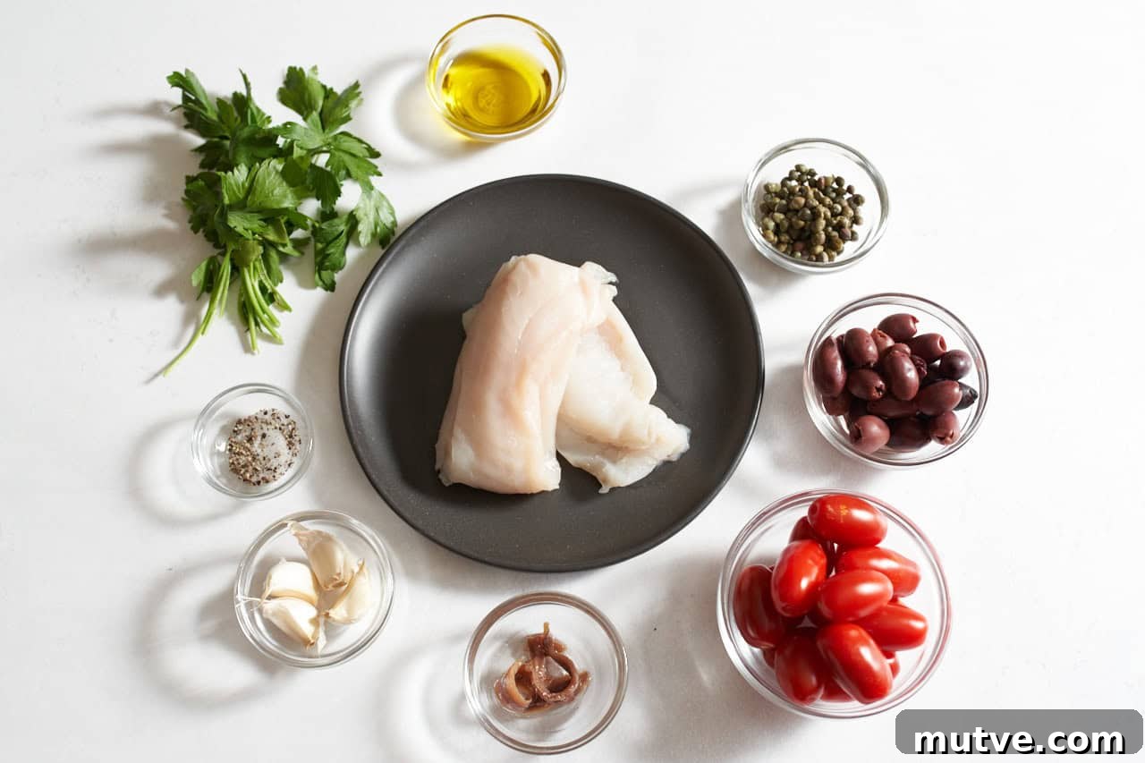 One-Pan Puttanesca Fish Recipe 3 Cod filets on a black plate surrounded by a small bunch of fresh parsley and small bowls of salt and pepper, garlic cloves, anchovies, grape tomatoes, kalamata olives, capers, and olive oil.